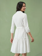 Woman wearing a white dress against a green background