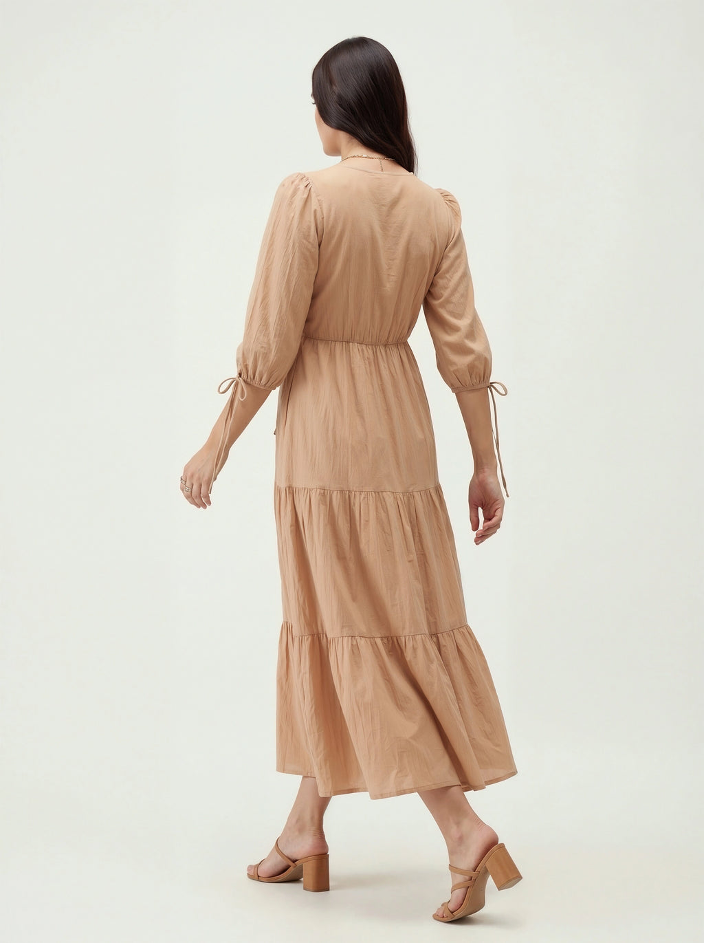 Woman wearing a beige dress on a white background