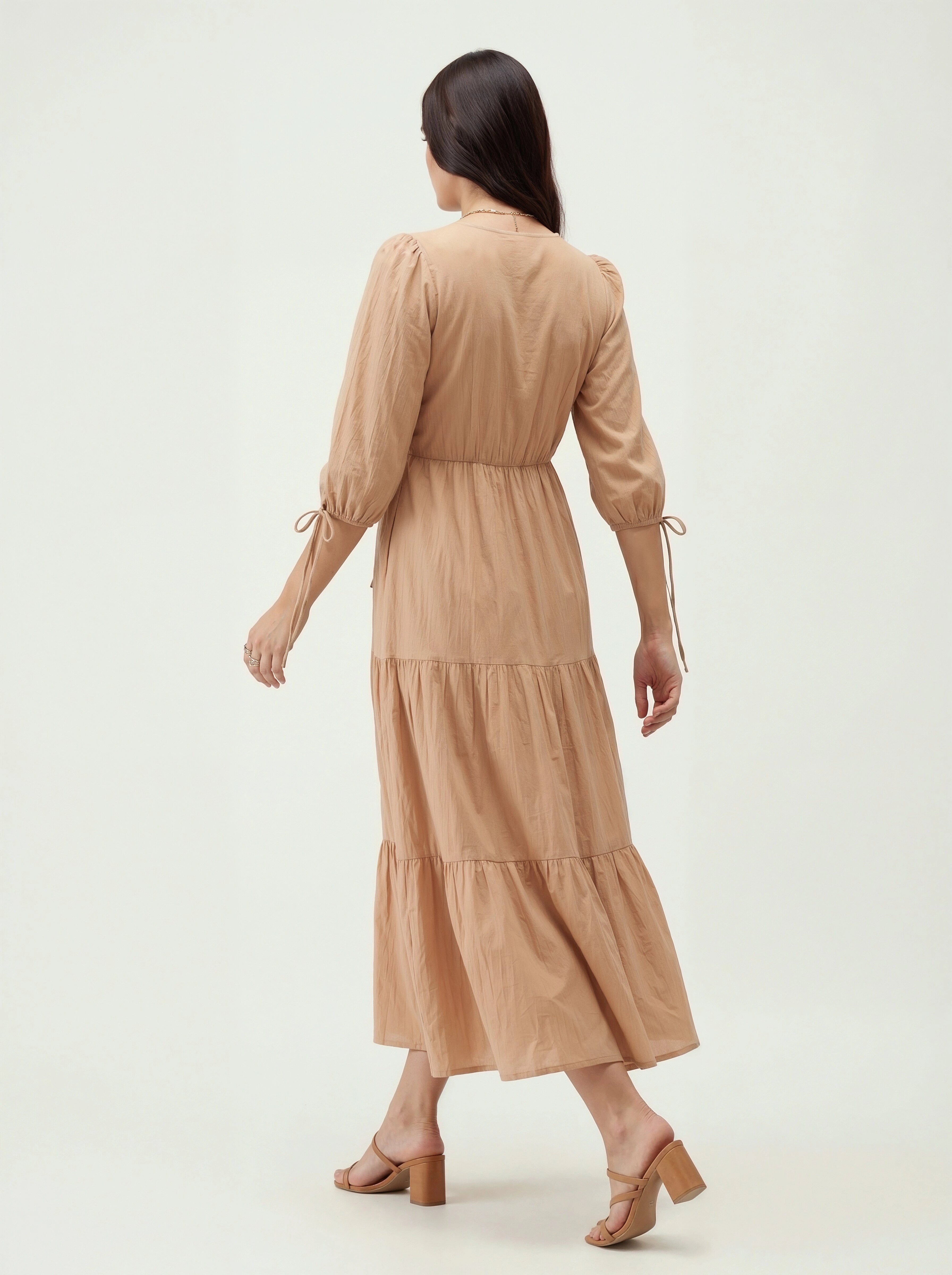 Woman wearing a beige dress on a white background