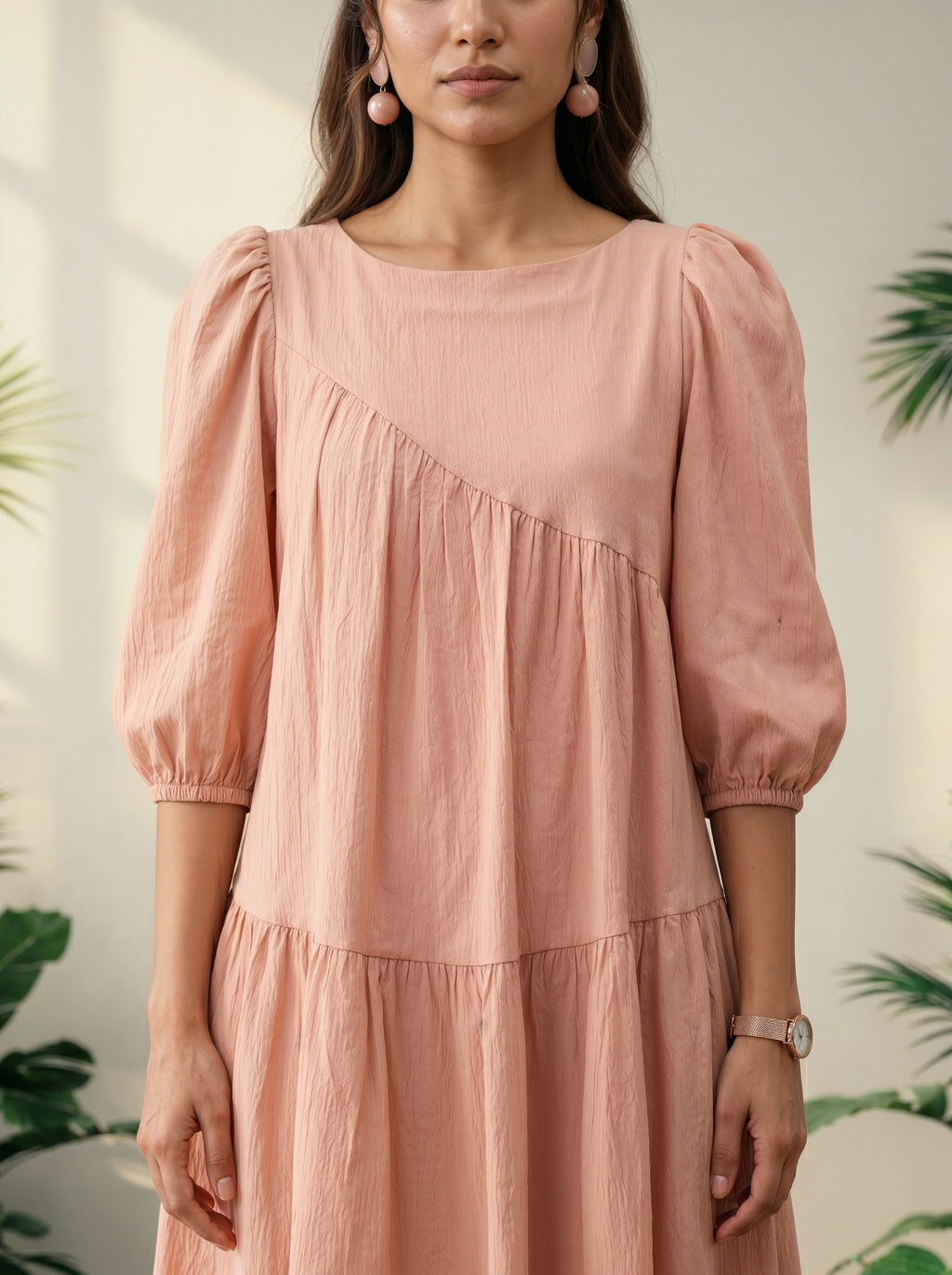 Woman wearing a pink dress with puff sleeves against a blurred natural background