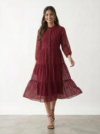 Woman wearing a burgundy dress with a white background