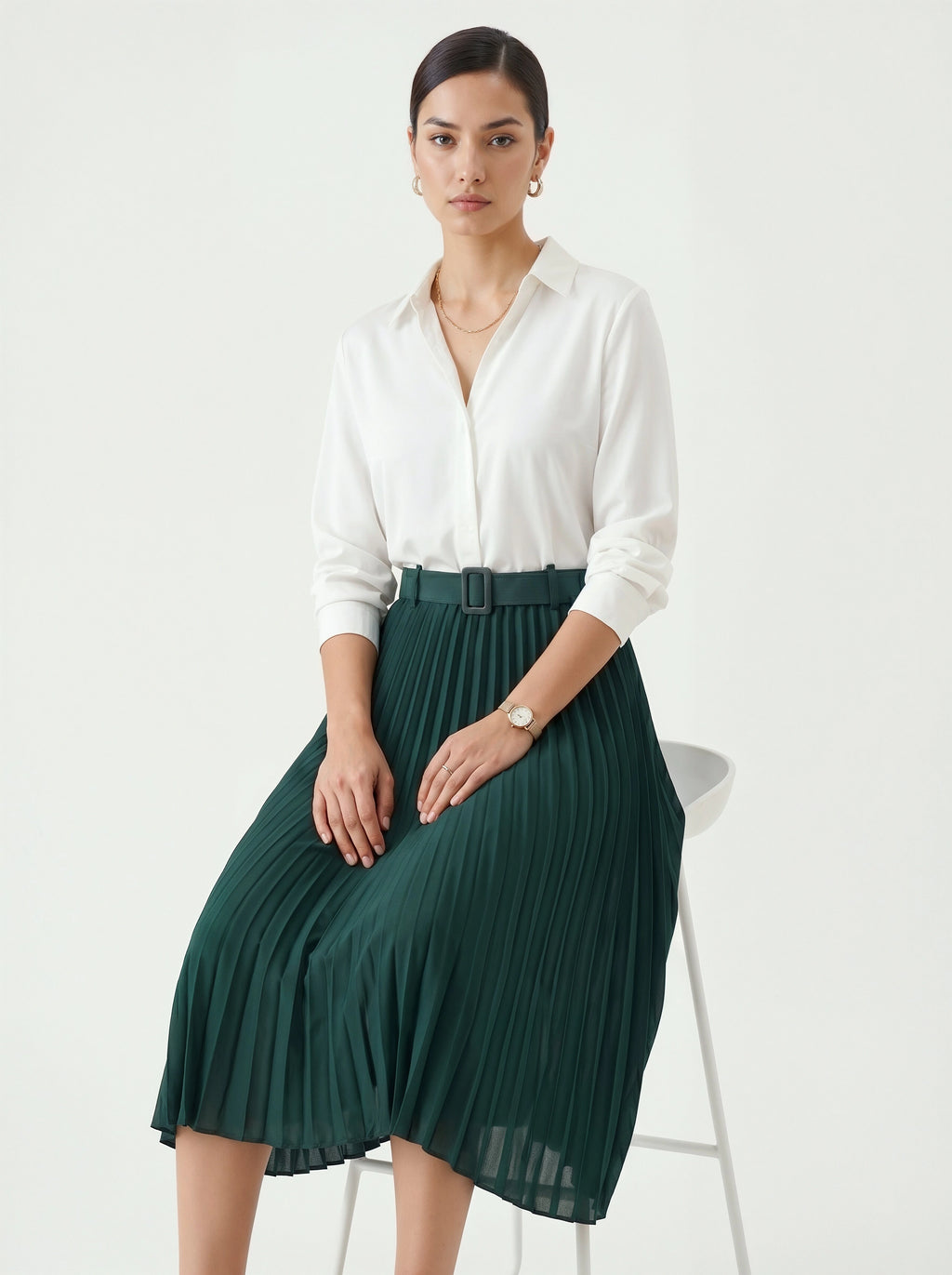 Woman wearing a white shirt and green pleated skirt on a white background