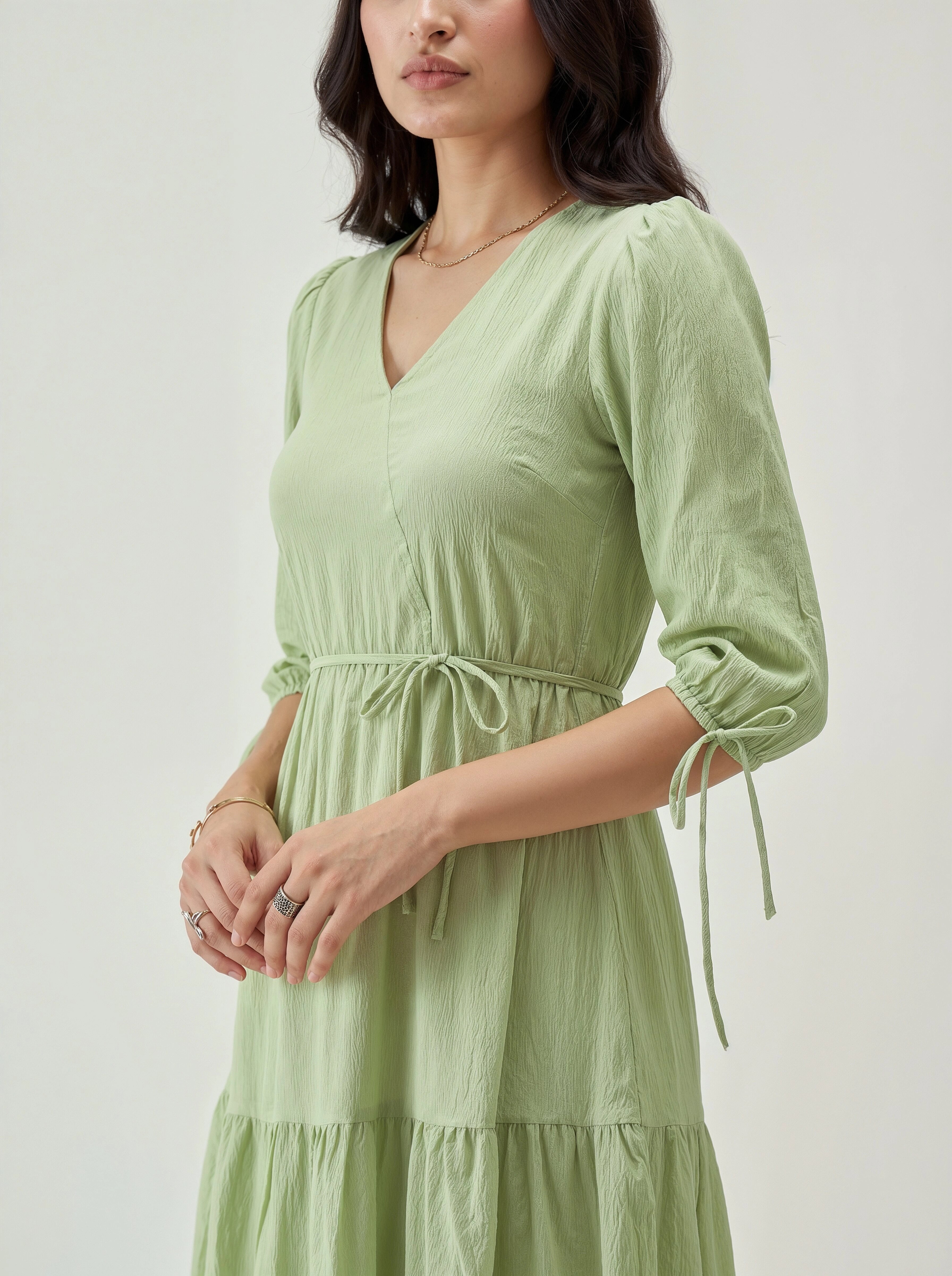 Woman wearing a light green dress with a plain background