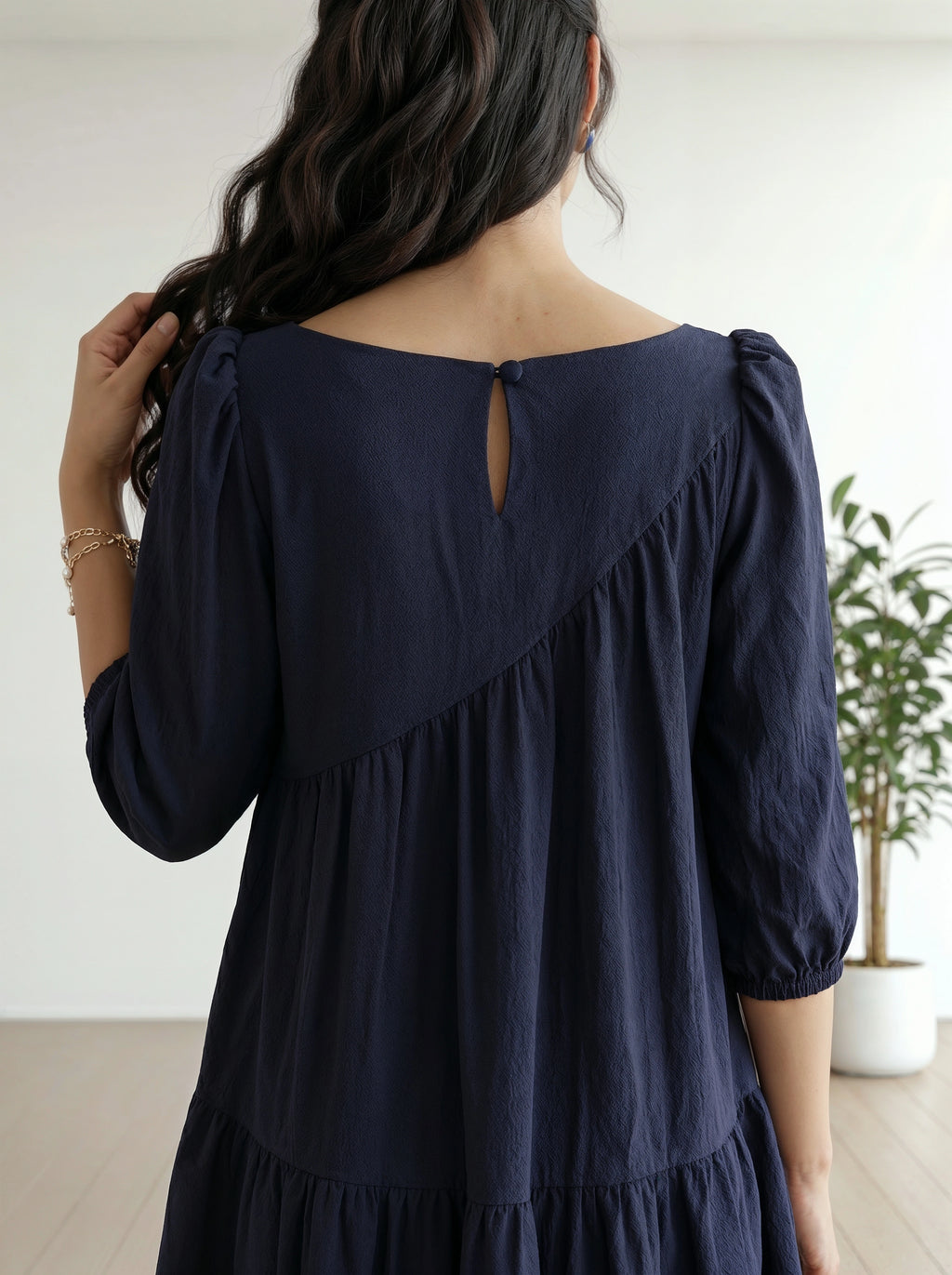Navy blue dress worn by a person with a white background