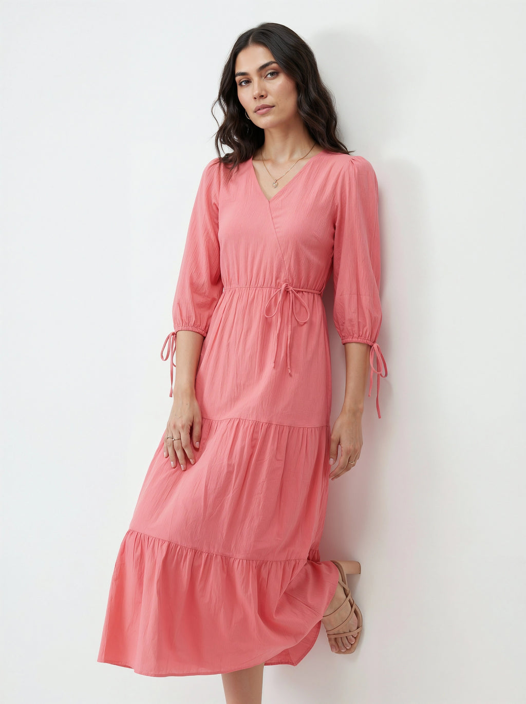 Woman wearing a pink dress against a white background
