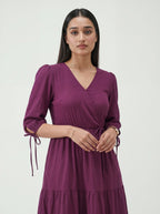 Woman wearing a purple dress against a white background