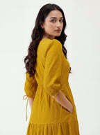 Woman wearing a yellow dress against a white background