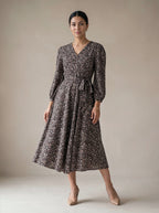 Woman wearing a floral dress against a plain background