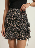 Black floral skirt worn by a person on a neutral background