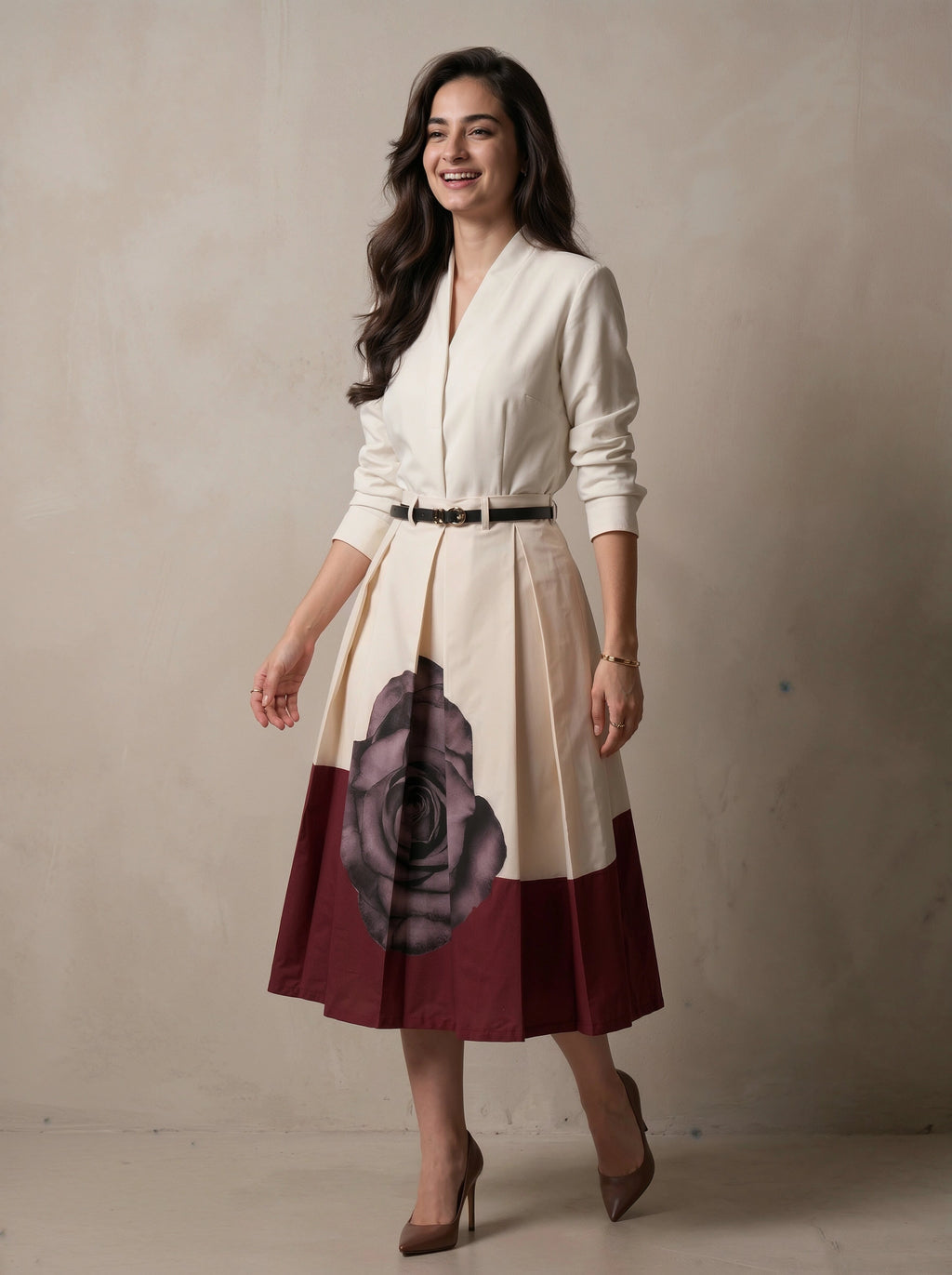 Woman wearing a white blouse with a floral skirt against a plain background