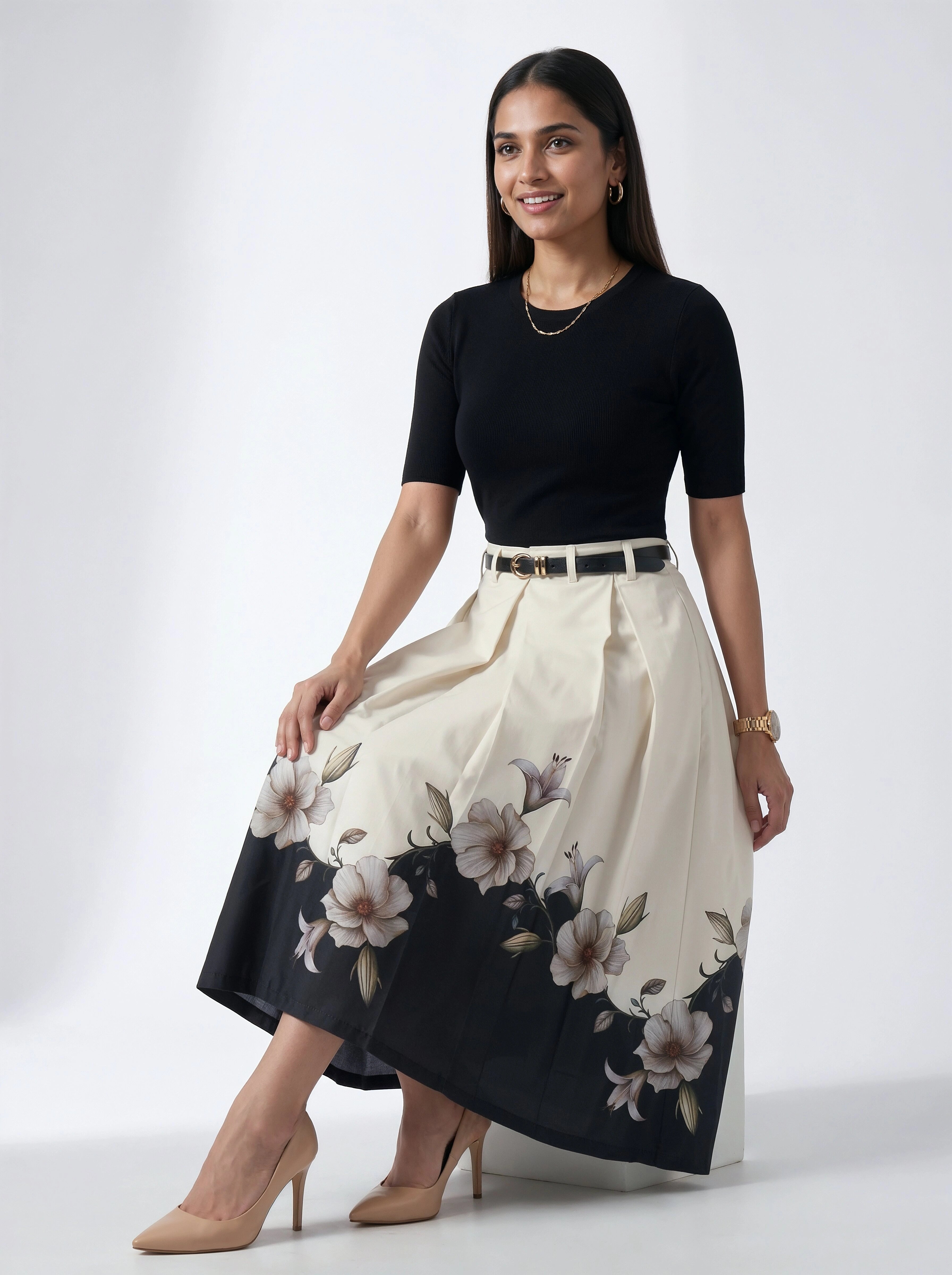 Woman wearing a black top and floral skirt on a white background