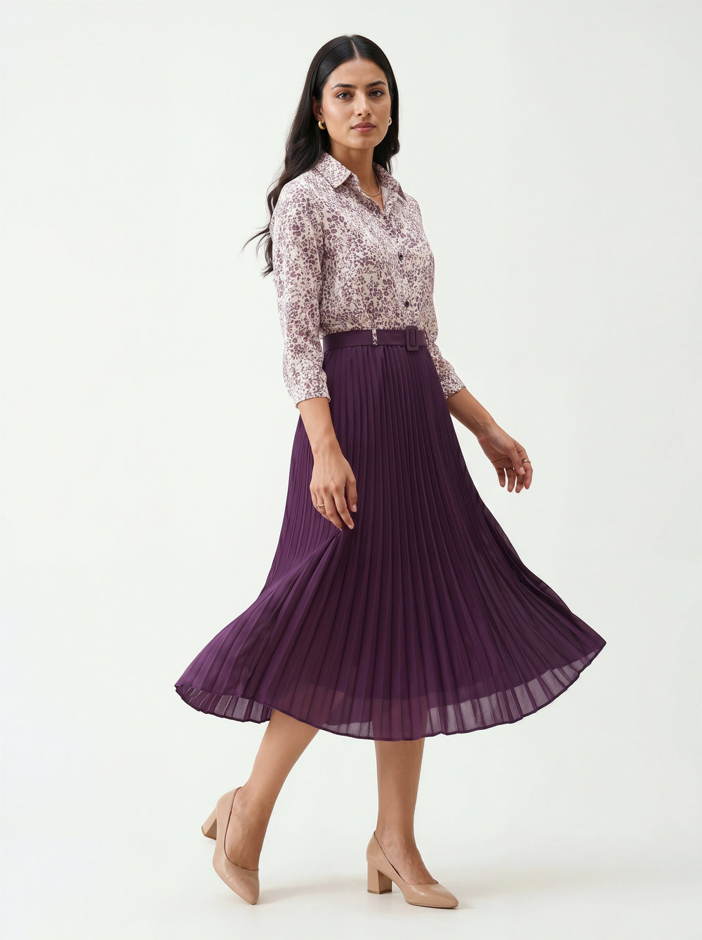 Woman wearing a floral blouse and purple pleated skirt on a white background