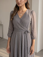 Woman wearing a gray patterned dress indoors
