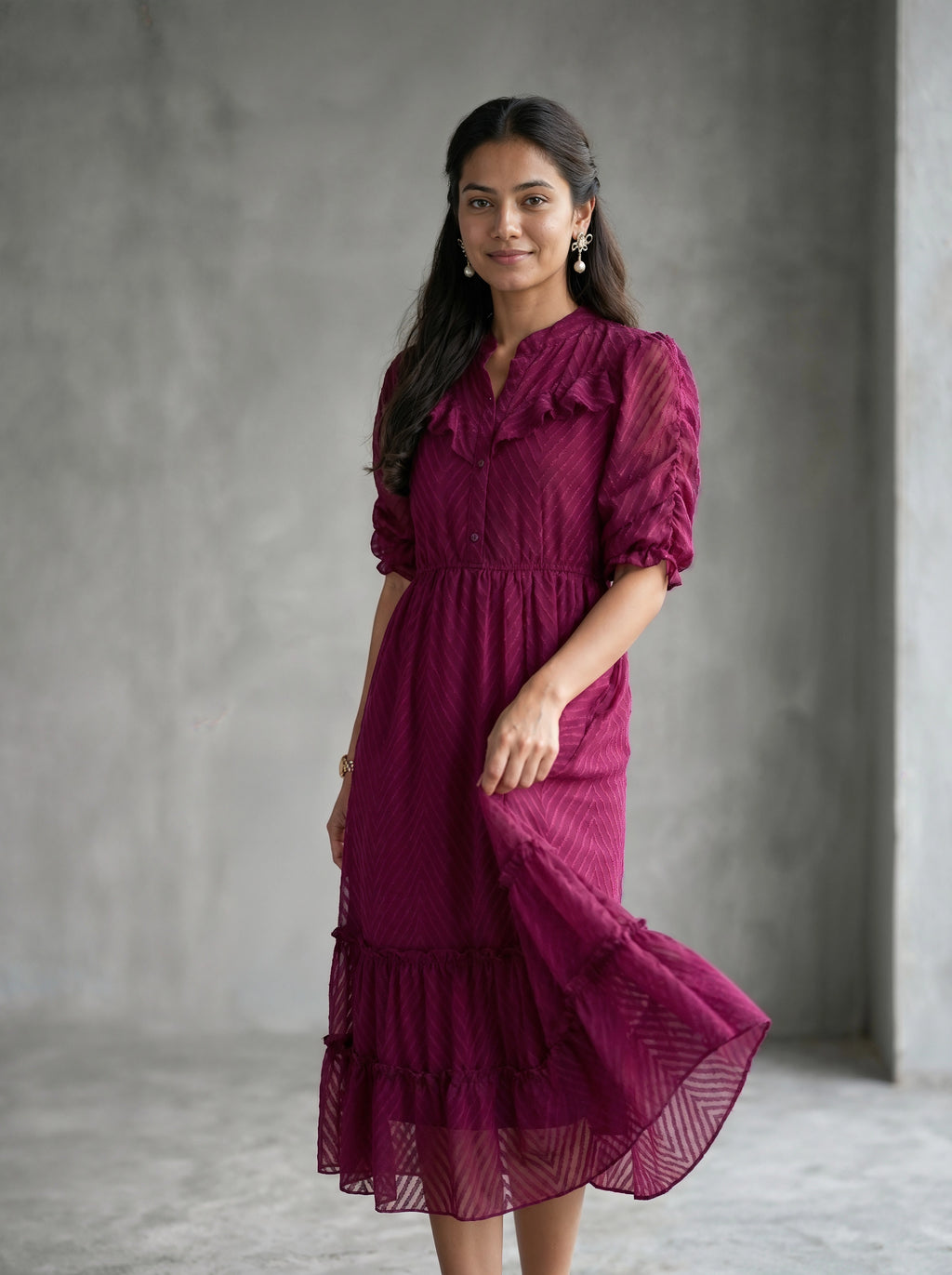 Woman wearing a burgundy dress against a beige background