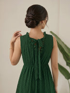 Woman wearing a green dress with a beige background