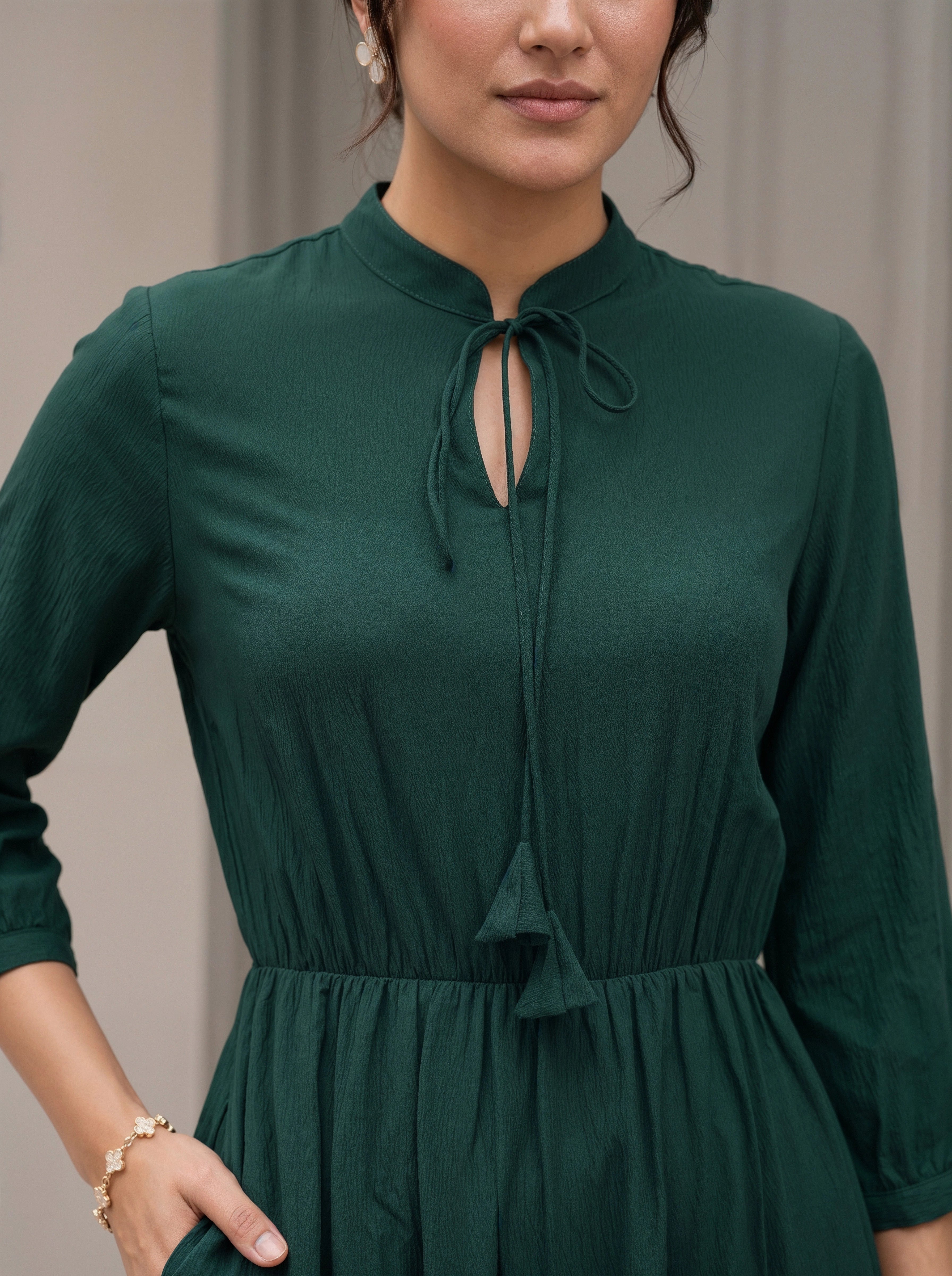 Woman wearing a green dress with a plain background