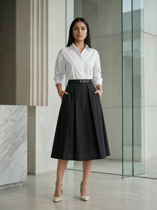 Woman wearing a white shirt and black skirt in an indoor setting