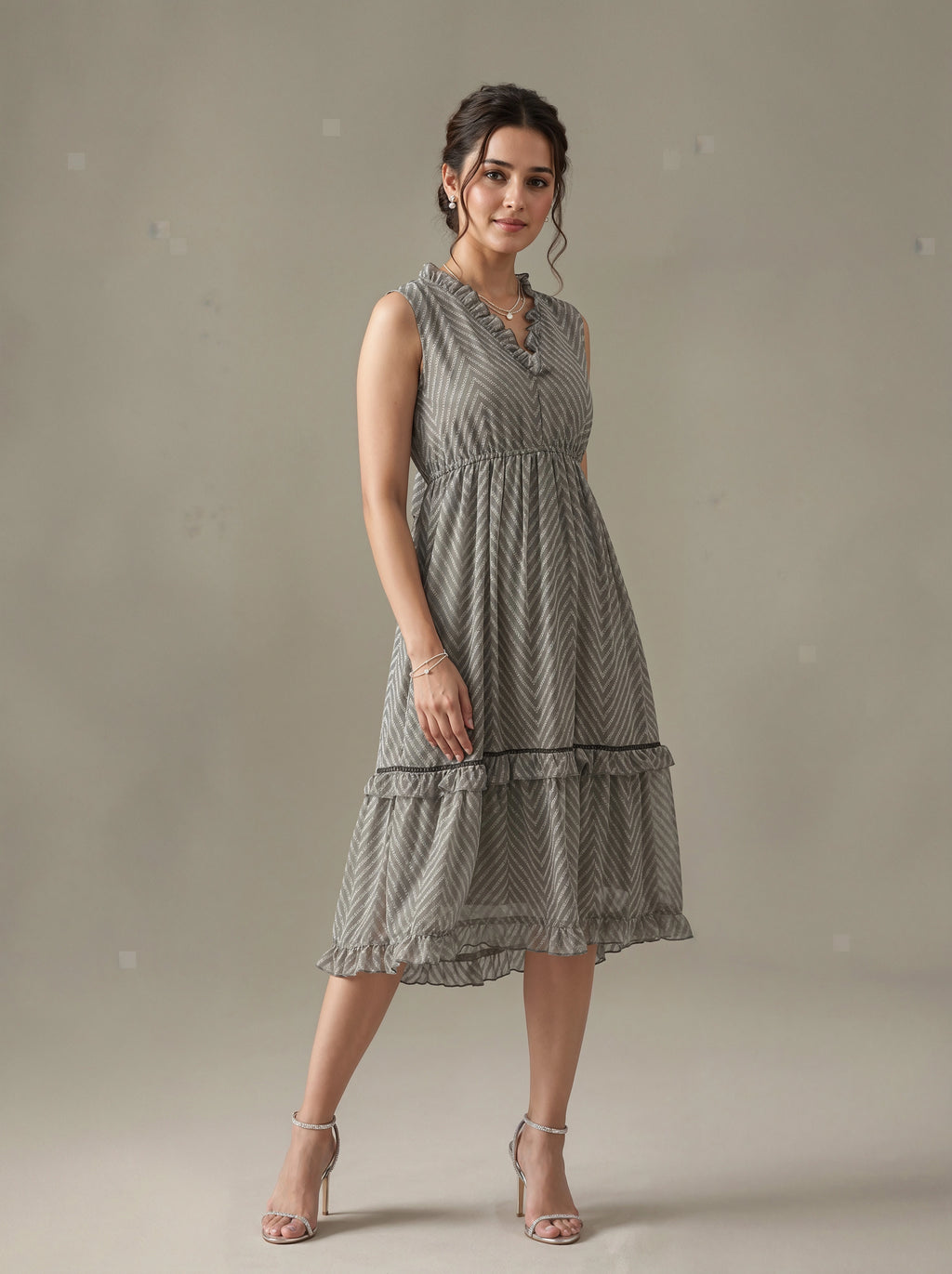 Woman wearing a gray patterned dress against a plain background