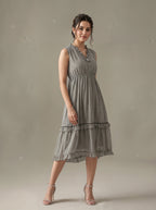 Woman wearing a gray patterned dress against a plain background