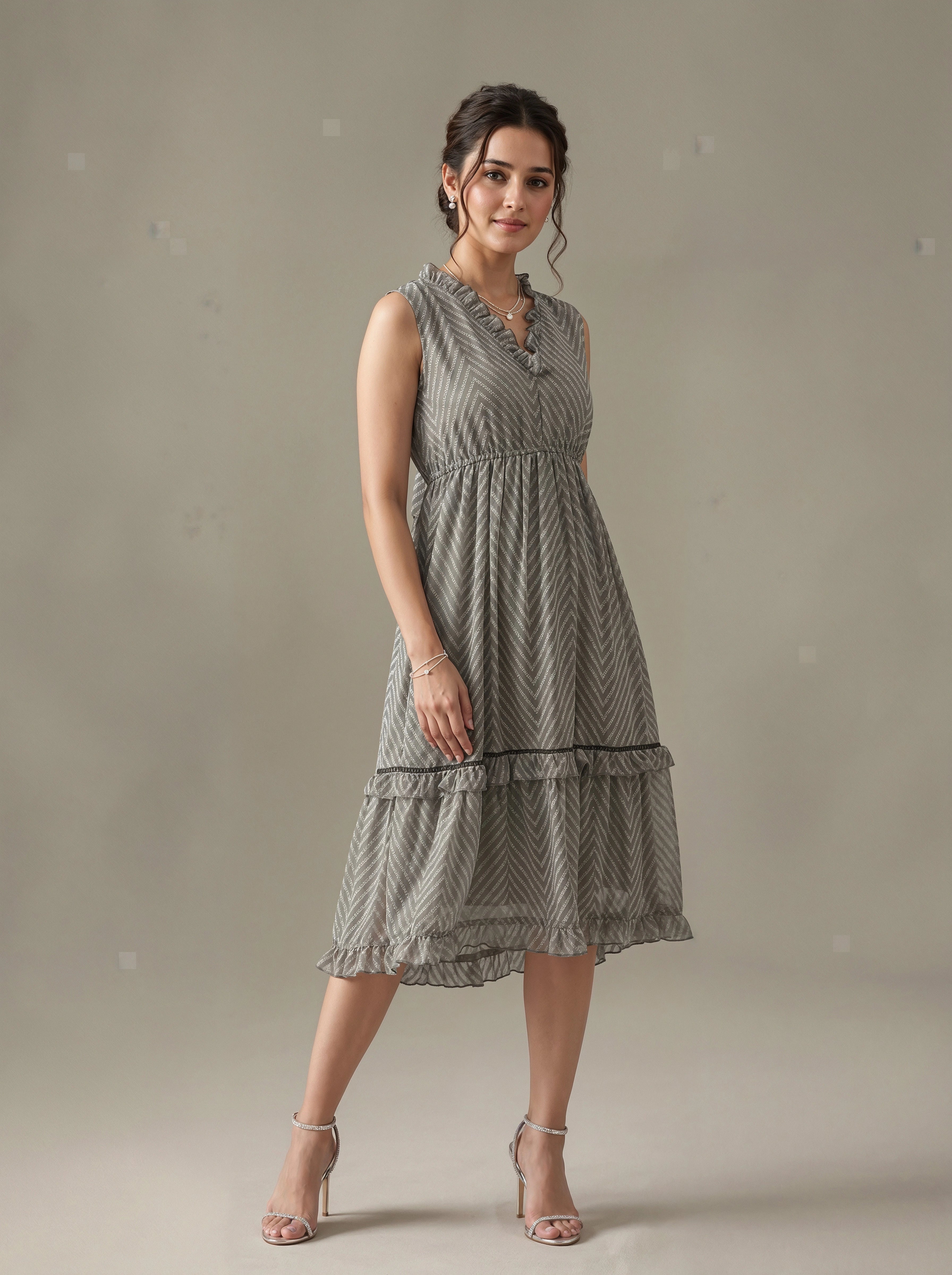 Woman wearing a gray patterned dress against a plain background