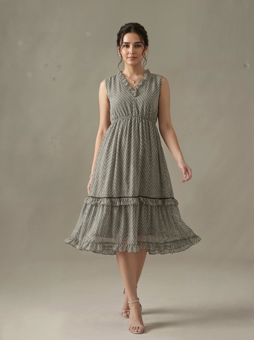 Woman wearing a sleeveless, patterned dress against a plain background