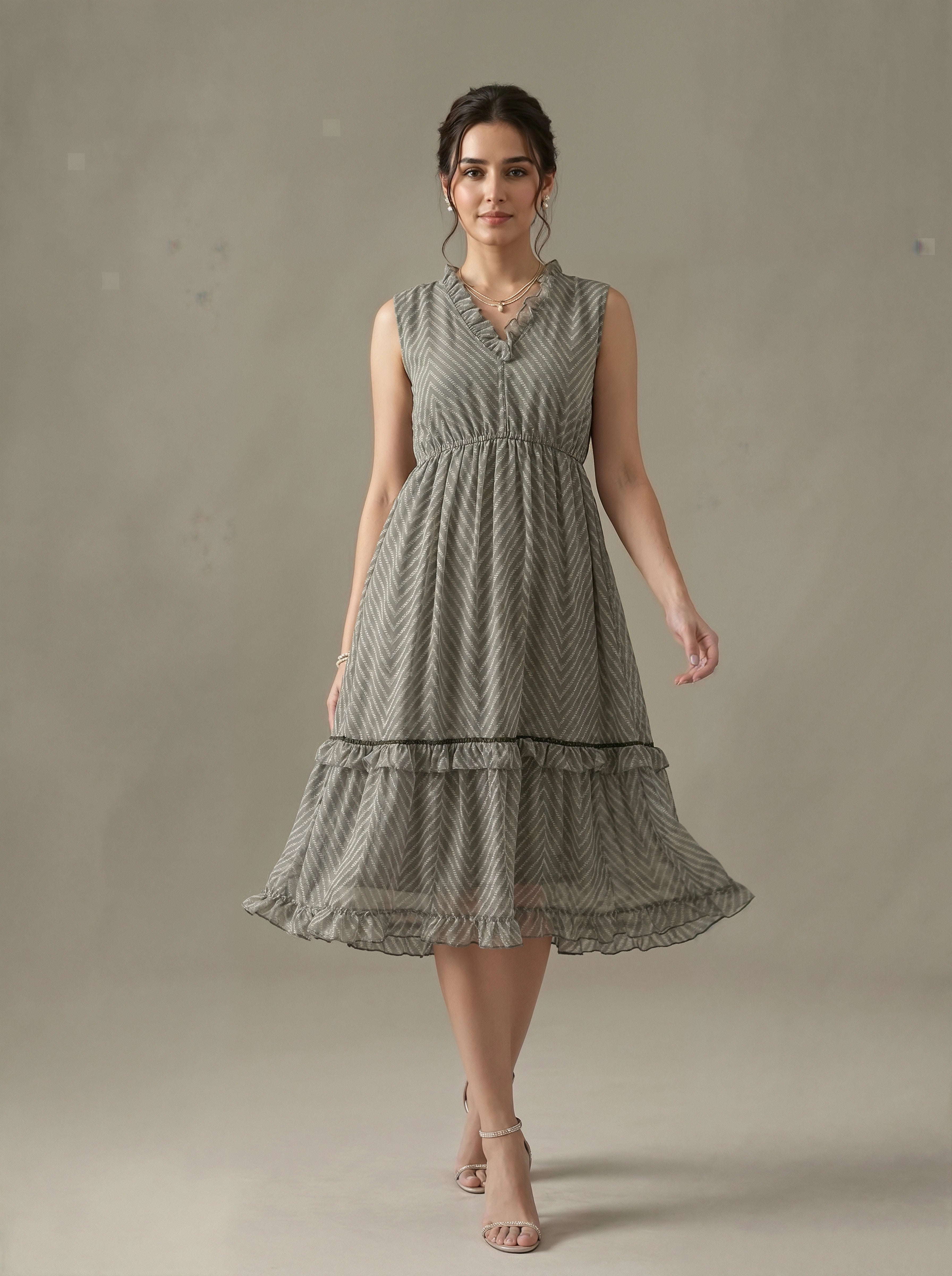 Woman wearing a sleeveless, patterned dress against a plain background