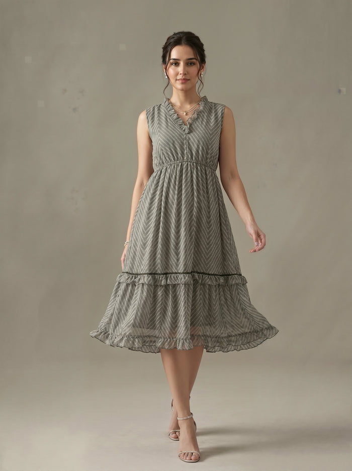 Woman wearing a sleeveless, patterned dress against a plain background