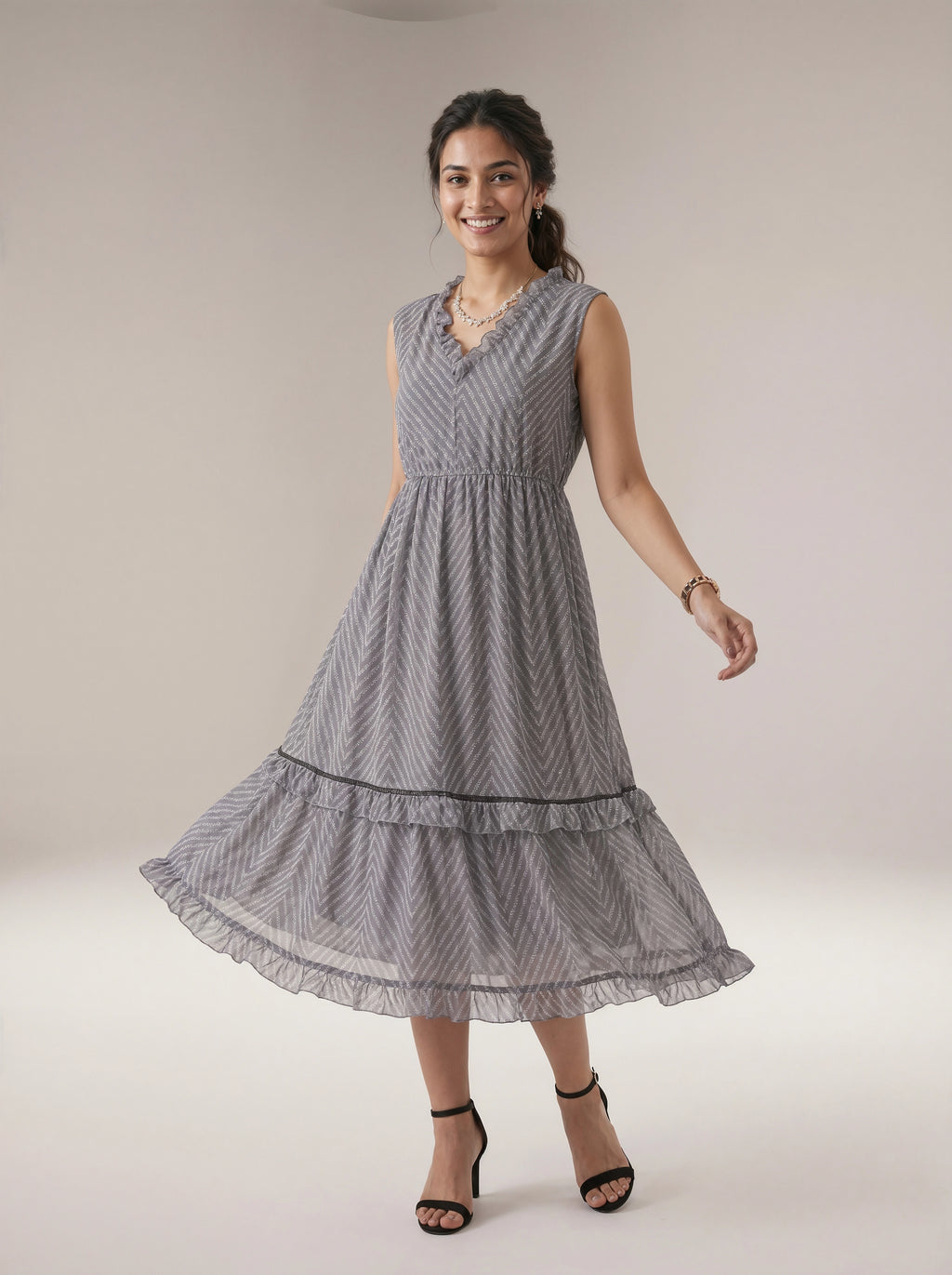 Woman wearing a gray patterned dress on a plain background