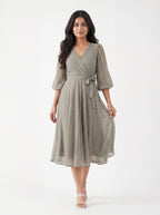 Woman wearing a gray dress with a white background