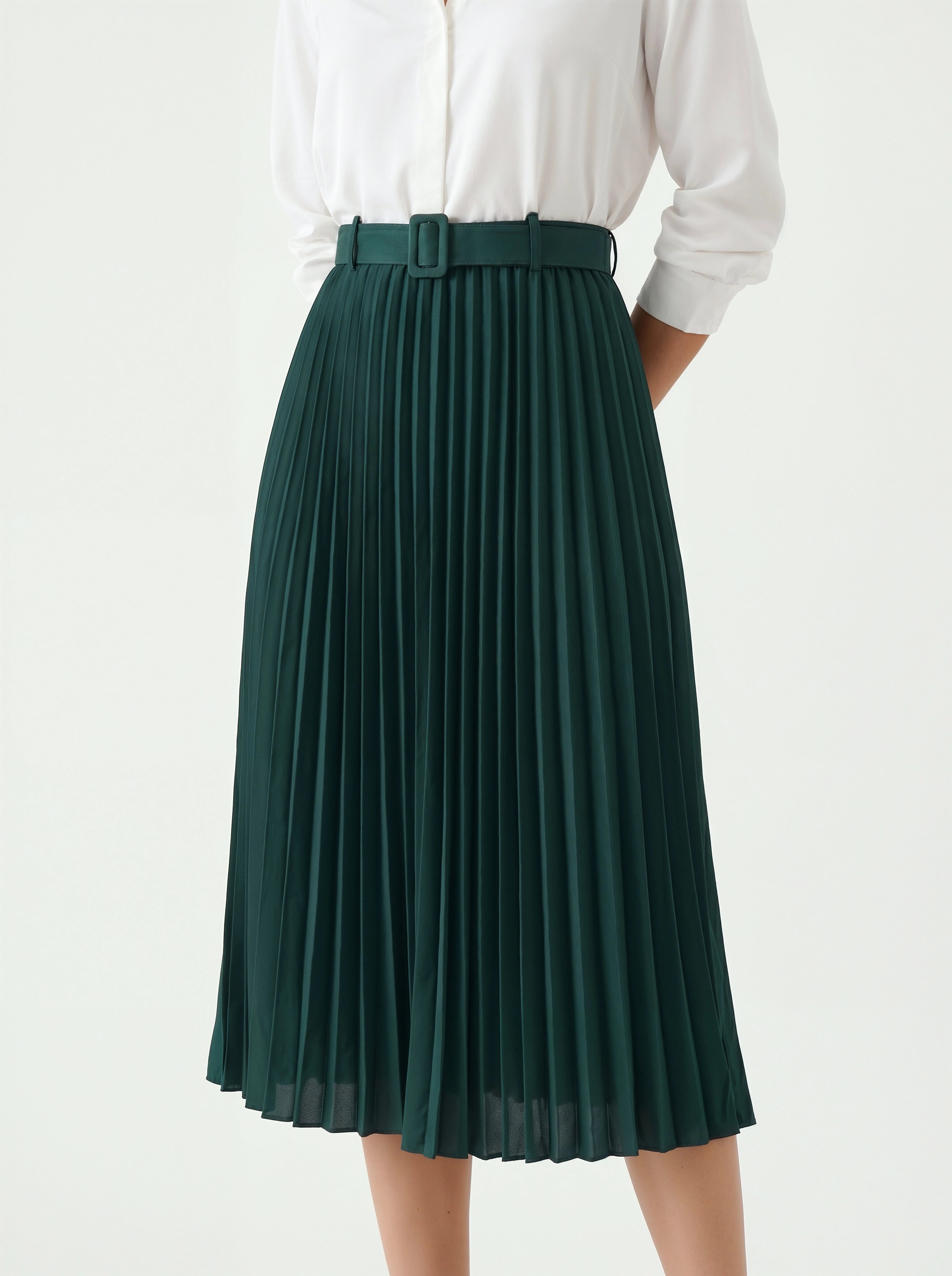 Green pleated skirt worn with a white shirt on a white background