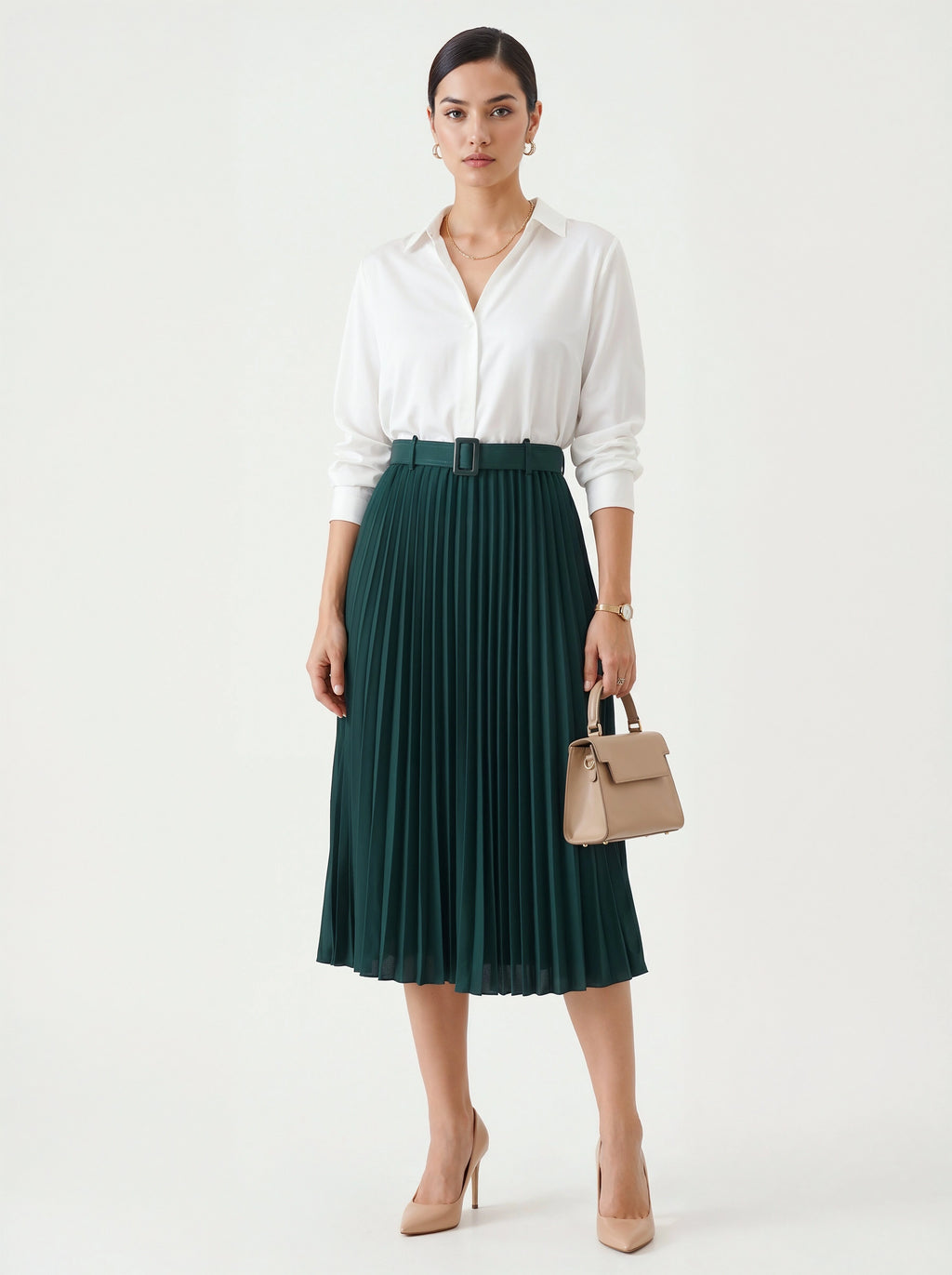 Woman wearing a white blouse and green pleated skirt holding a beige handbag on a white background