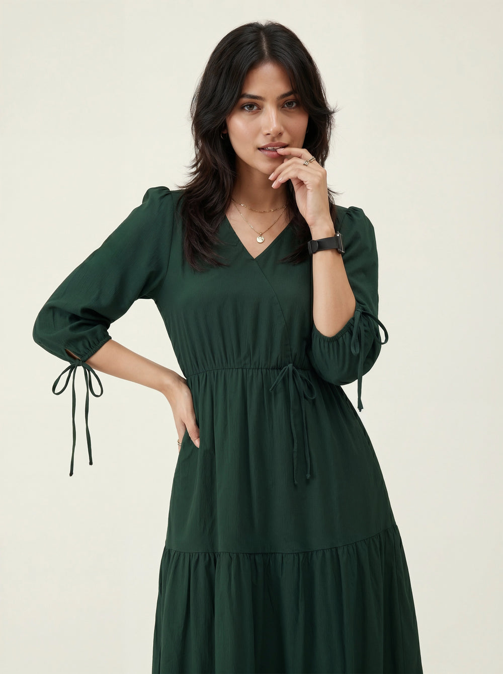 Woman wearing a green dress on a plain background