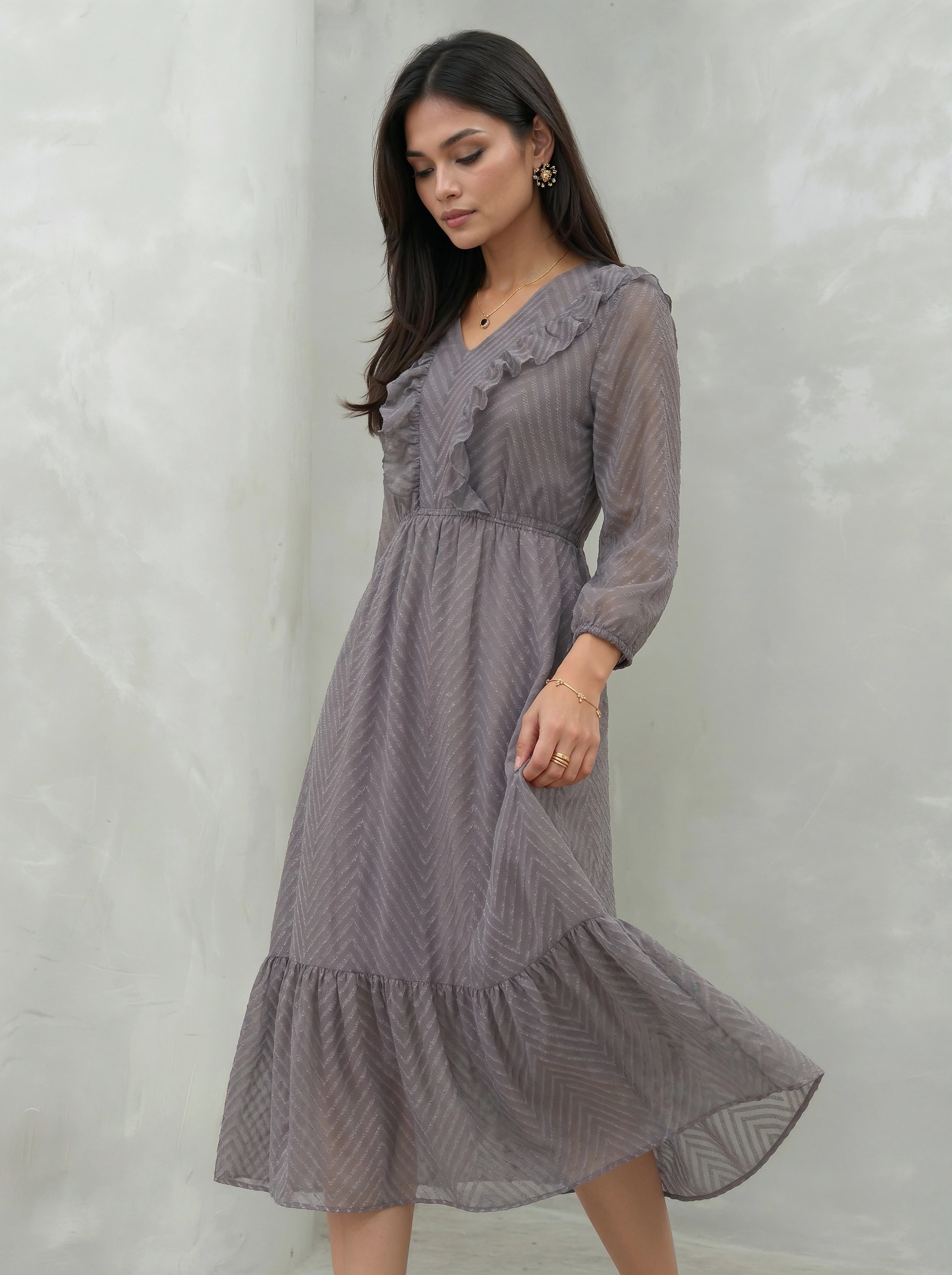 Woman wearing a gray dress against a plain background