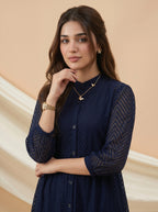Woman wearing a navy blue dress with a beige background