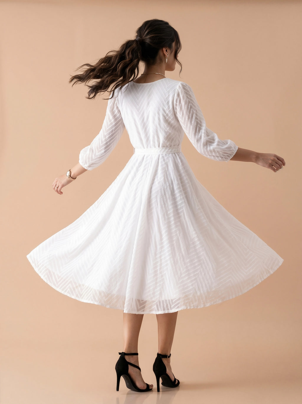 Woman wearing a white dress against a beige background