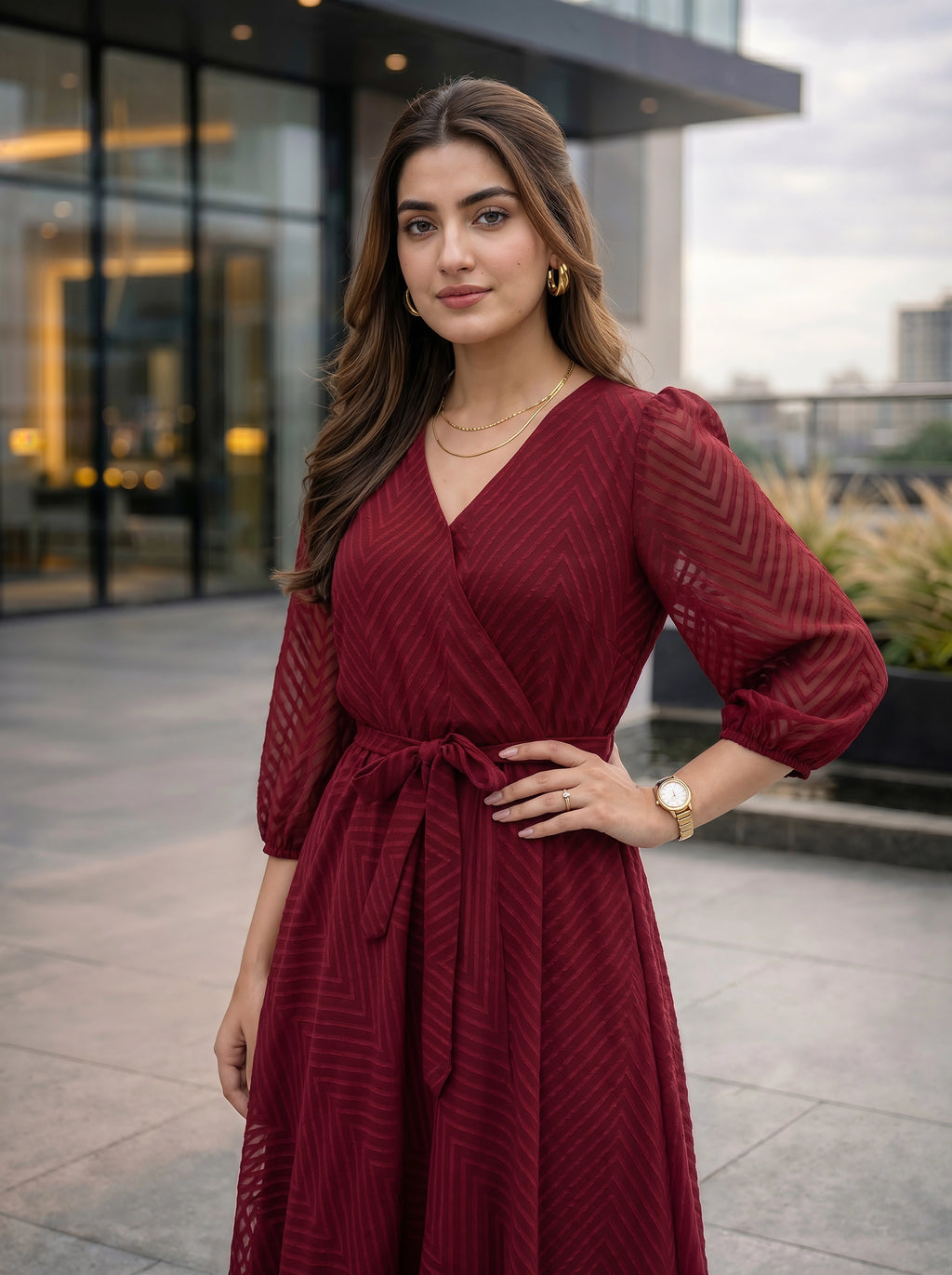 Woman in a red dress standing outdoors with modern building in the background