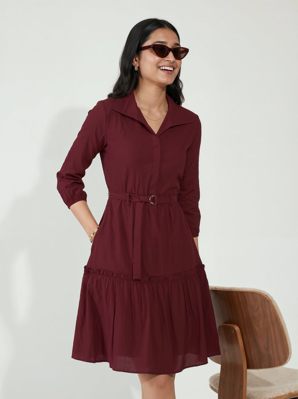 Woman wearing a burgundy dress with a white background