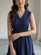 Woman wearing a navy blue dress with a neutral background