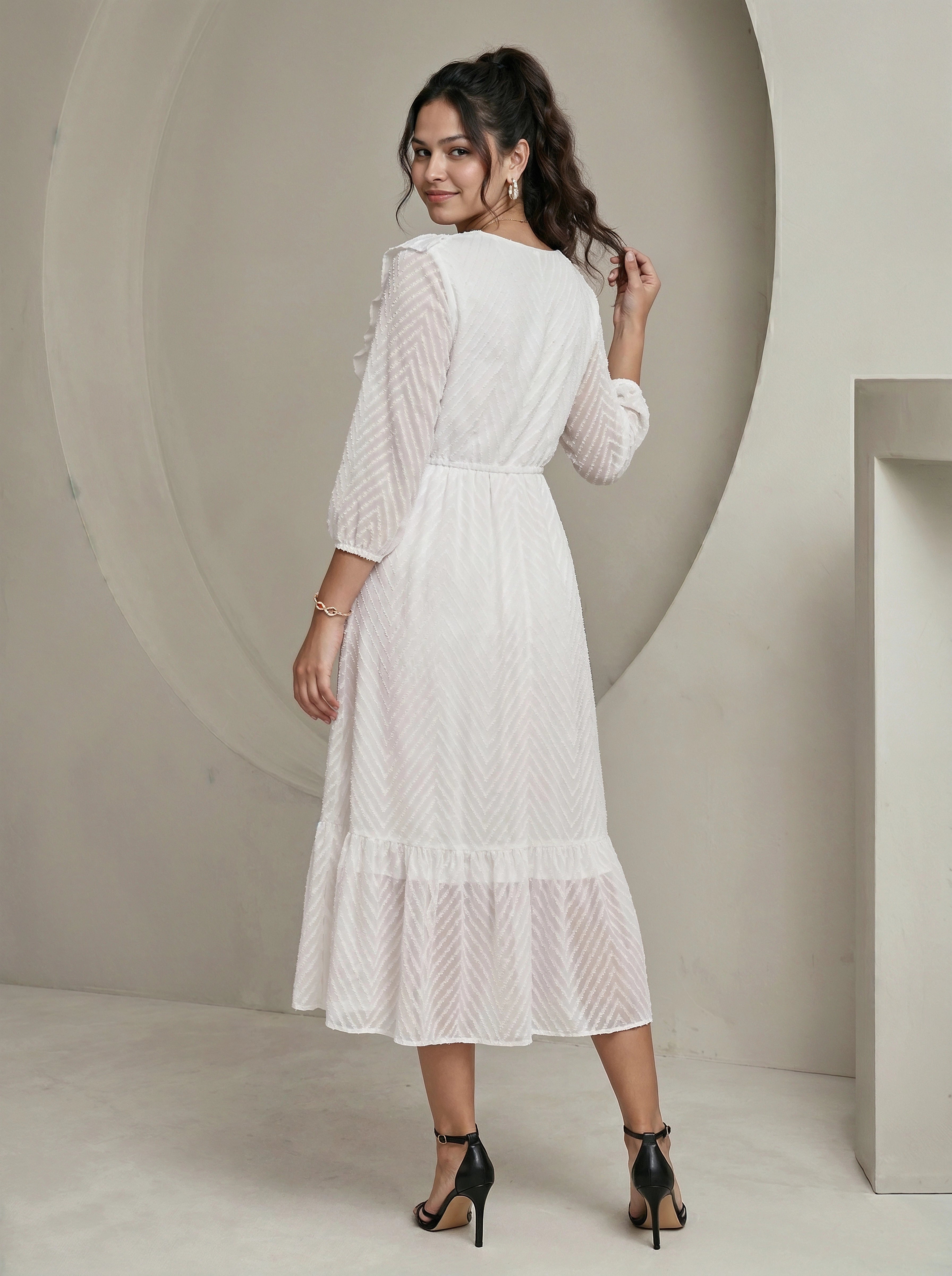 Woman wearing a white dress in a minimalistic setting