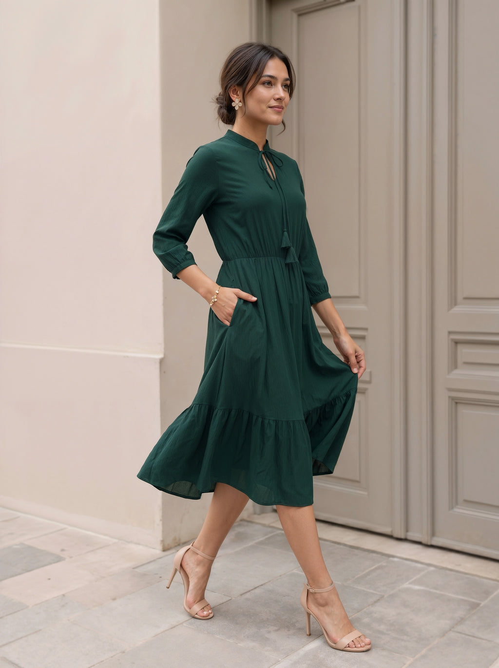 Woman in a green dress standing in front of a door.