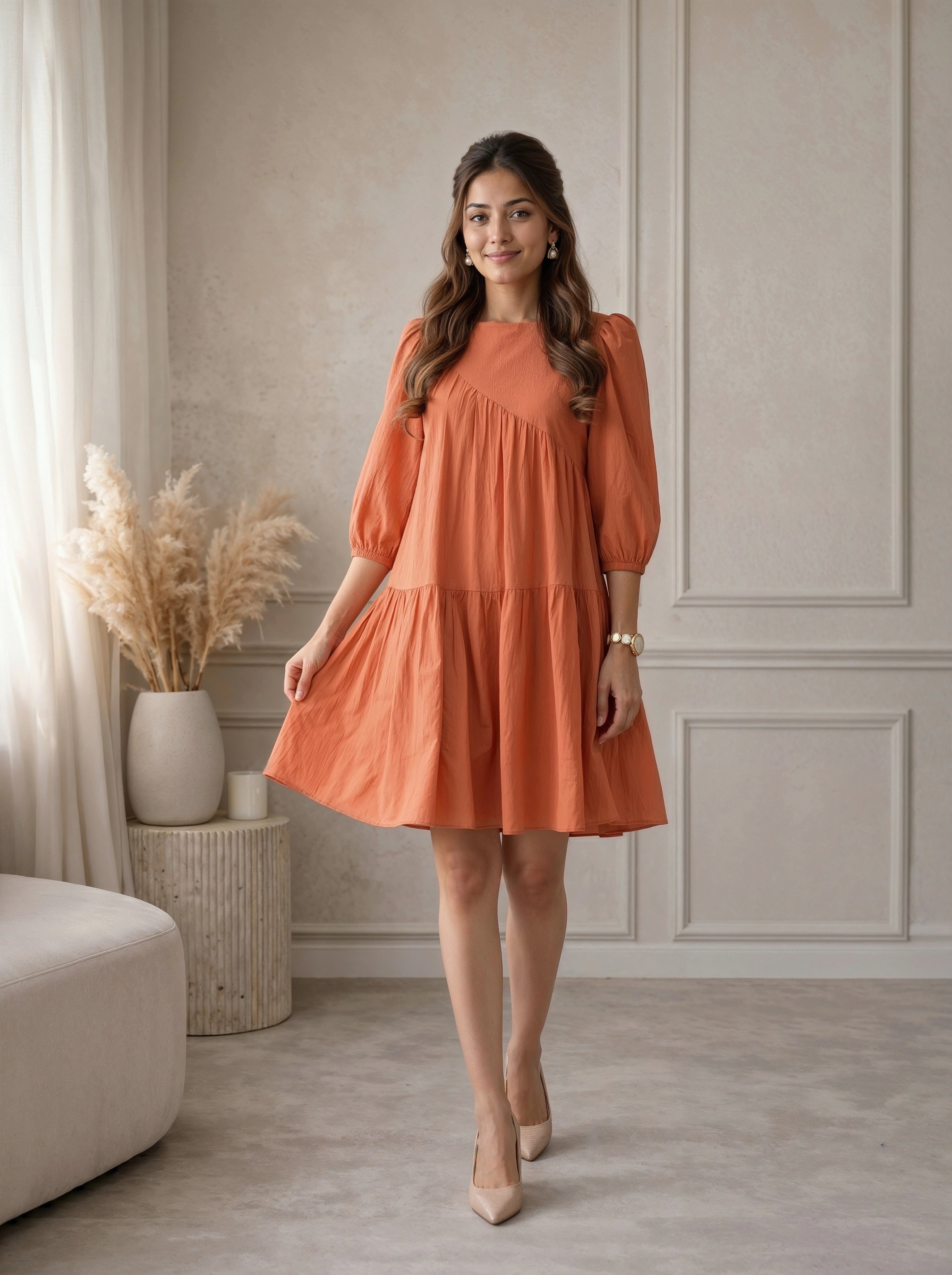 Woman wearing an orange dress standing in a room with neutral decor.