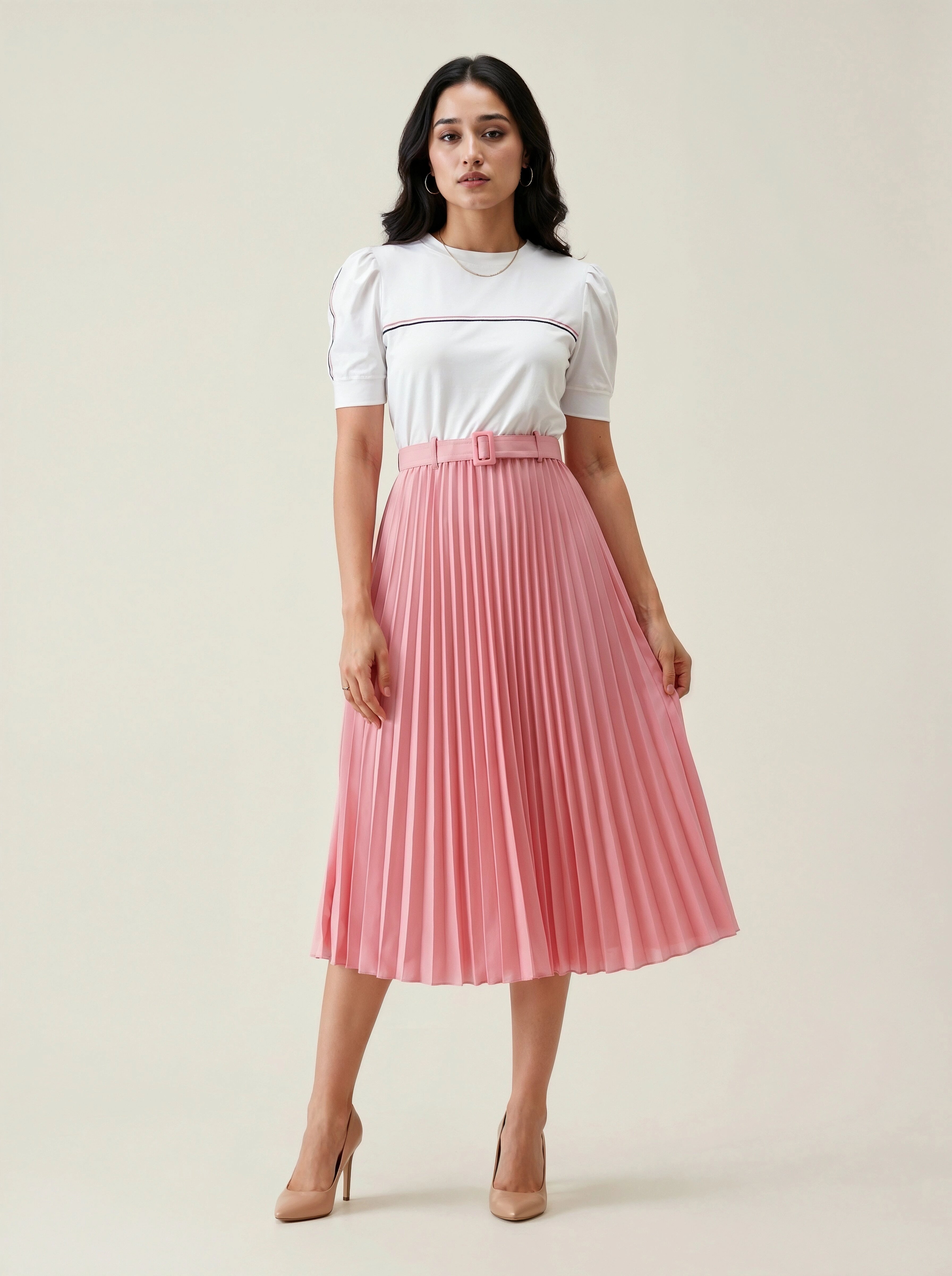 Woman wearing a white top and pink pleated skirt on a beige background