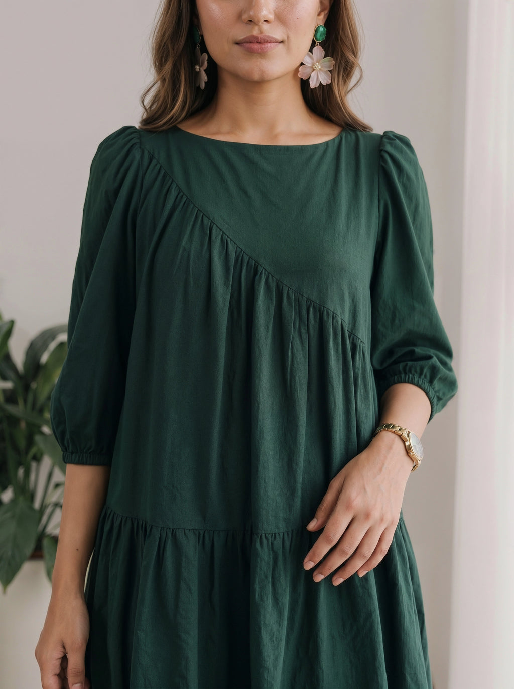 Woman wearing a green dress with a neutral background