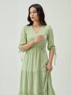 Woman wearing a light green dress against a white background