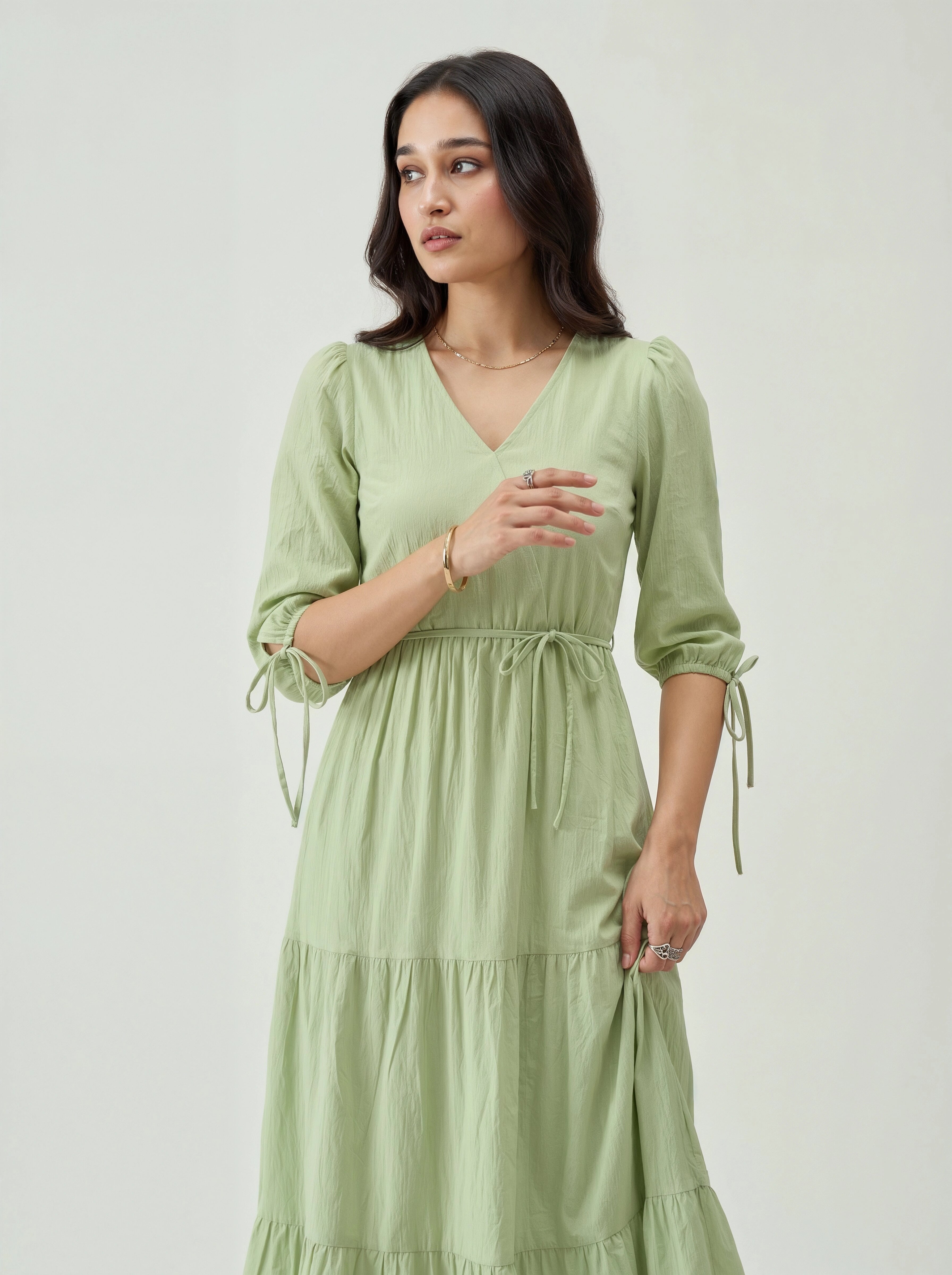 Woman wearing a light green dress against a white background