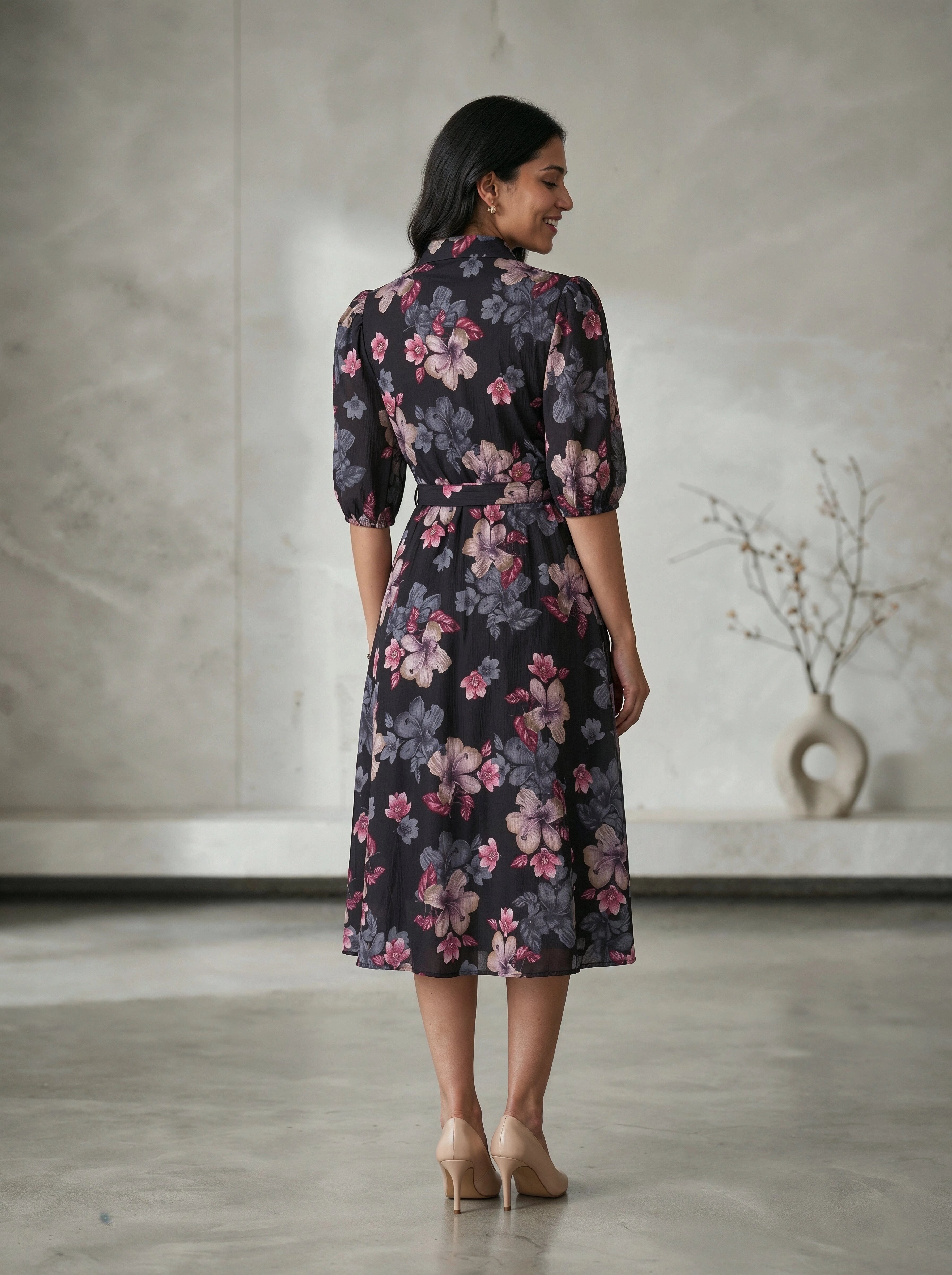 Woman wearing a floral dress in a minimal indoor setting