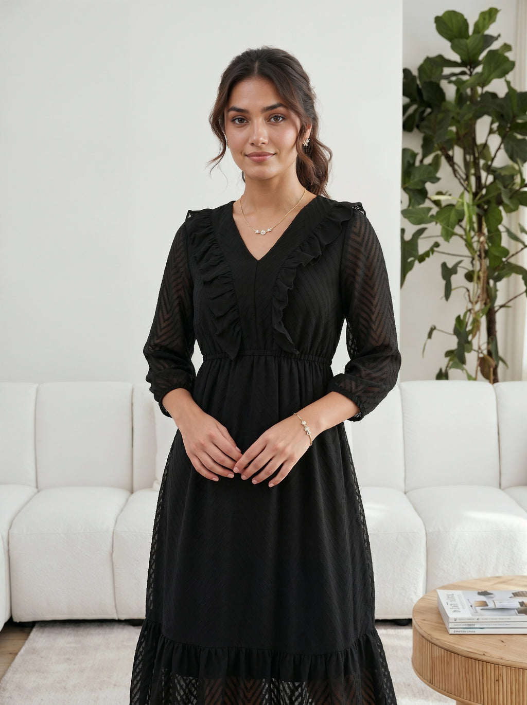 Woman wearing a black dress standing in a living room.