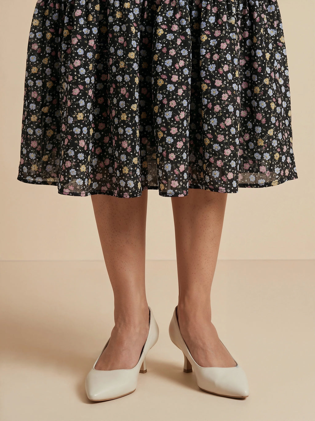 Floral patterned skirt worn by a person on a beige background