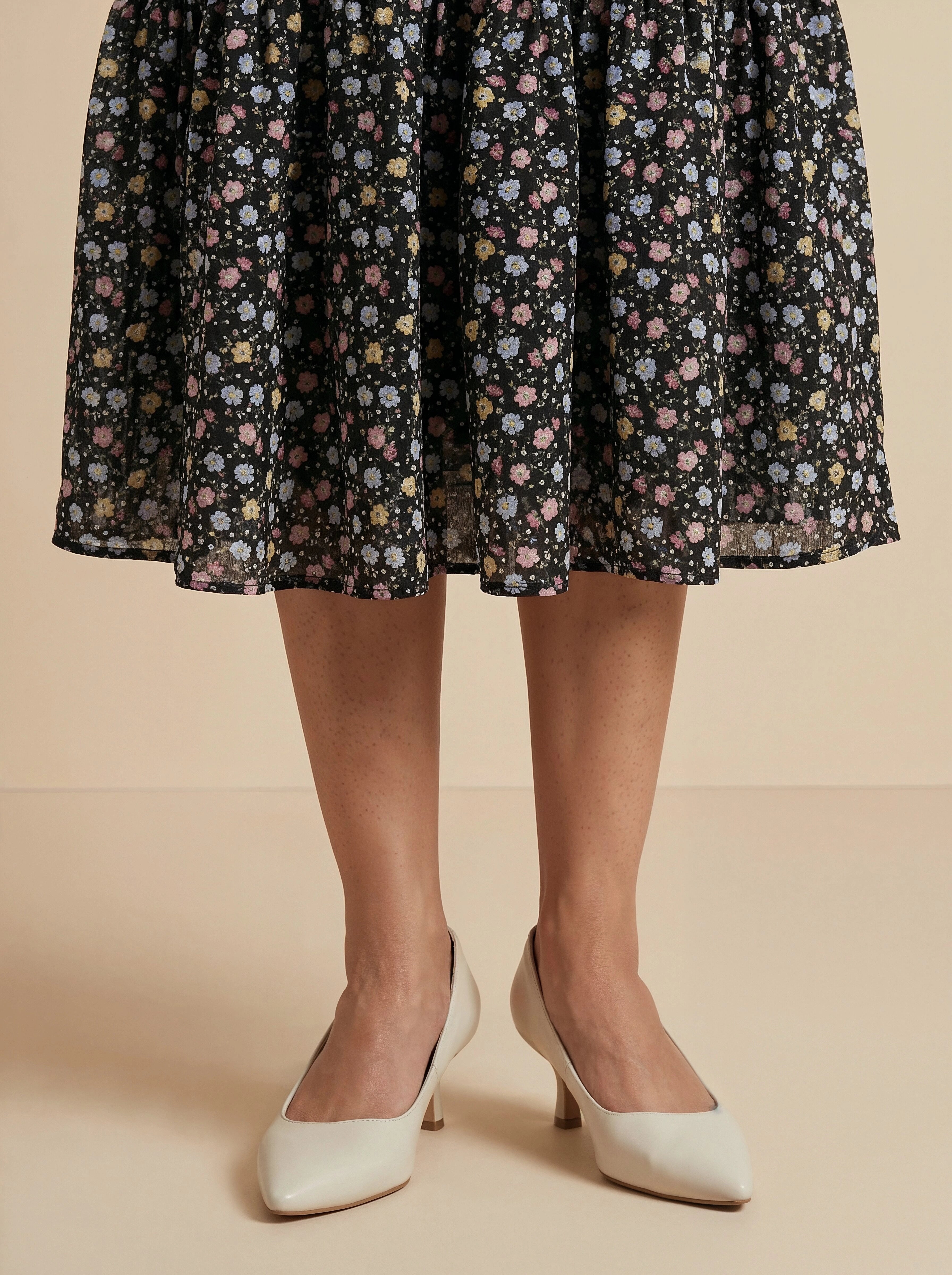 Floral patterned skirt worn by a person on a beige background