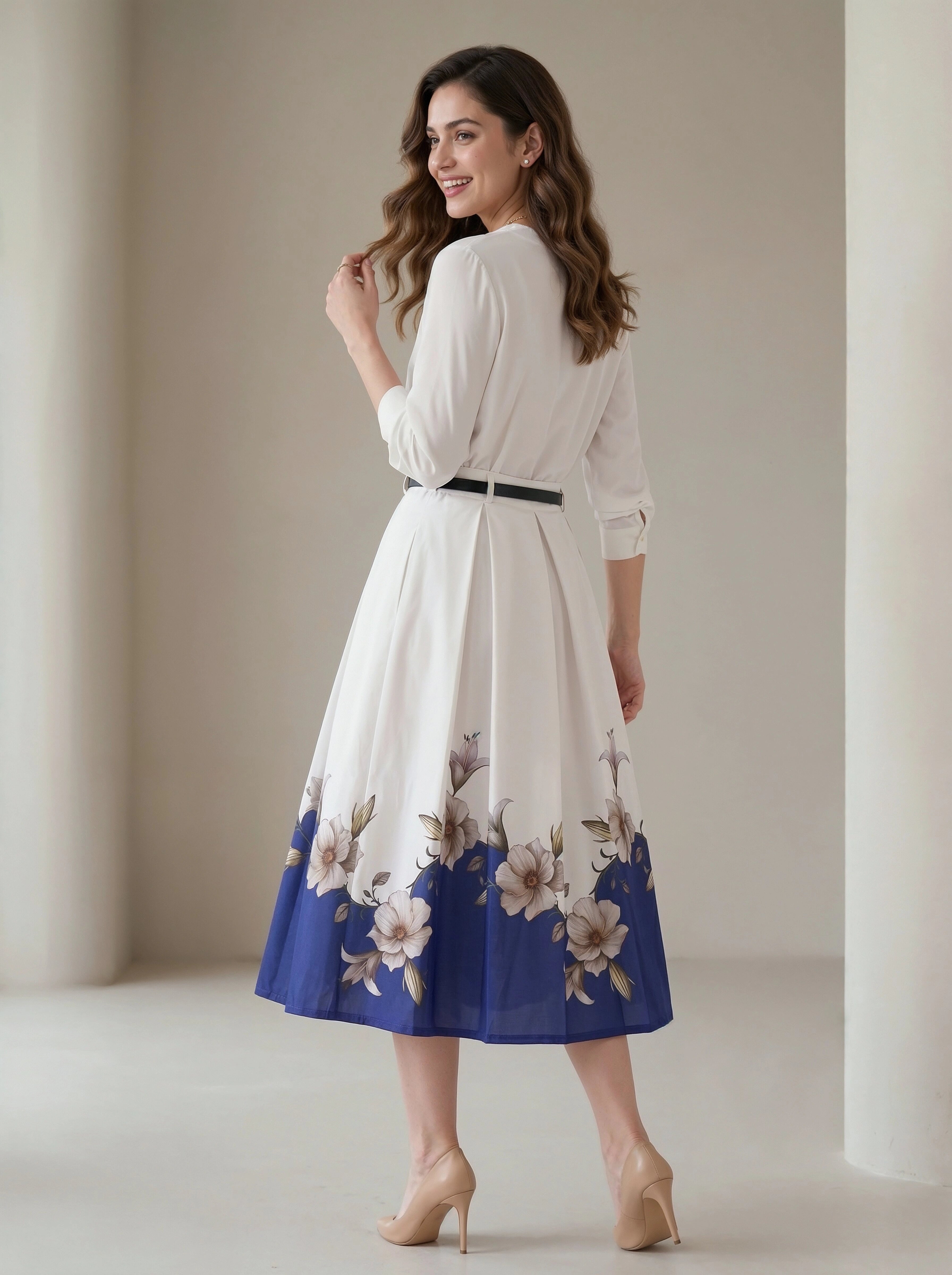 Woman wearing a white dress with floral blue hem in a neutral setting